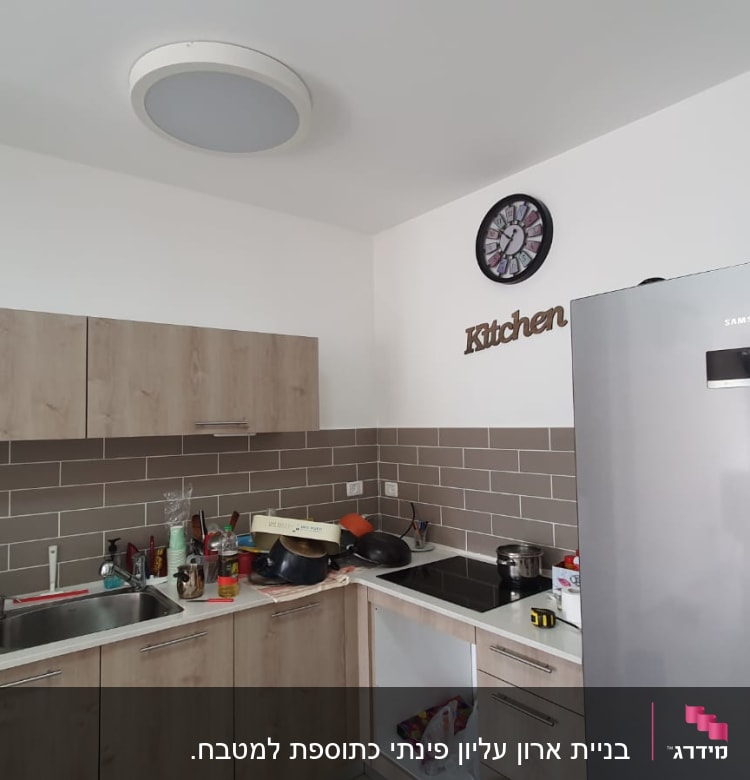 מטבח עם ארונות עץ, כיור ותנור